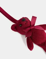 Llavero con dije de oso de peluche de corderoy color borgoña, con moño de cinta de raso al cuello y cinta para colgar.