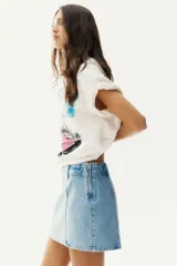 Minifalda de jean celeste, de corte evasé, con cintura alta y cierre lateral oculto.