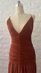 Vestido largo de microtul color terracota, con breteles finos, escote en V pronunciado y fruncido en la cintura.
