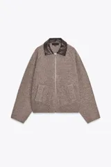 Chaqueta de punto color marrón claro con cuello solapa a contraste en simil cuero color marrón oscuro y manga larga. Cierre frontal con cremallera metálica.