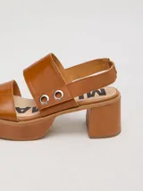 Sandalias negras de cuero con plataforma y taco ancho. Tienen correa trasera con elástico y doble argolla en la parte externa e interna.