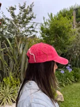 Gorra de algodón tipo denim color azul con bordados artesanales de líneas onduladas en colores contrastantes. Presenta una visera curva y ajuste regulable en la parte posterior.