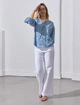 Blusa celeste con estampado floral blanco, escote en V y botones. Mangas 3/4 abullonadas con terminación elastizada.