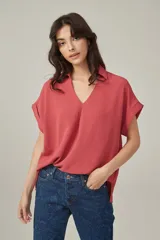 Blusa color salmón de viscosa, corte holgado, con cuello camisero y mangas cortas con dobladillo.
