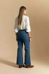 Jean oxford de tiro alto, color azul oscuro, con costuras frontales marcadas y corte acampanado progresivo desde la rodilla.