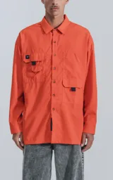 Camisa naranja de manga larga, estilo técnica con múltiples bolsillos delanteros y un bolsillo en la parte inferior de espalda, botones en cartera y mangas, calce oversize.
