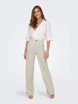 Pantalón de vestir color beige, de tiro medio y corte recto. Confeccionado en mezcla de lino y viscosa, con cierre de botón y cremallera, trabillas para cinturón y detalle de pinzas.