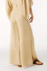 Pantalón de lino color beige, de corte palazzo y tiro alto.