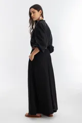 Pantalón de lino negro, súper ancho, de tiro medio-alto con tablas delanteras y elástico en la parte trasera.