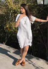 Vestido amarillo de lino con cuello redondo y mangas cortas con dobladillo. Tiene botones de madera en los laterales.