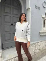Sweater gris con estampado de flores blancas, cuello en V y mangas largas.