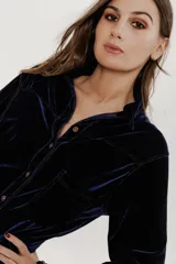 Camisa azul de terciopelo con corte estilo jean, bolsillo en la parte delantera y botones símil metal color oro viejo.