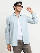 Camisa celeste de manga larga con cuello button-down, confeccionada en tejido rústico de algodón y lino.