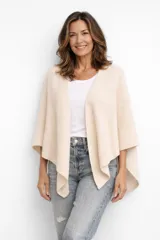 Poncho de punto color beige, con diseño abierto frontal y caída asimétrica.