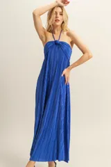 Vestido midi negro con textura plisada, escote halter y corte holgado.