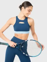Top deportivo azul con detalle de abertura en la parte frontal sobre el busto y almohadillas removibles.