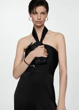 Mono largo negro de tejido fluido con cuello halter, detalle de nudo en el cuello y cierre de cremallera en la espalda.