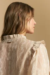 Camisa de manga corta abullonada con terminación elastizada, cuello con leve frunce y calce recto. Presenta una estampa floral integral sobre fondo claro.