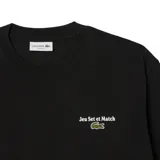 Remera negra de Lacoste con cuello redondo y manga corta. Estampado frontal con texto 'Jeu Set et Match' y logo de la marca.