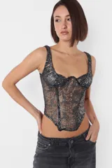 Corset lencero en tejido desagujado con foil, color gris y plateado. Recortes en delantero con ballena en interior. Busto con aro; taza media copa y superposición de breteles. Terminaciones con elástico dobladillado por interior. Acceso por espalda con cierre metálico YKK desmontable.