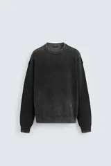 Sweater negro de algodón con cuello redondo, manga larga y terminaciones en rib.