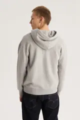 Buzo canguro con capucha y cierre frontal de la marca Levi's, color gris con logo bordado en el pecho. Tiene bolsillos laterales y puños y cintura acanalados.