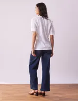 Blusa blanca de algodón con escote en V, abertura con botones y mangas cortas con detalle de broderie.