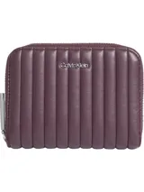 Billetera Calvin Klein de tamaño mediano color borgoña, con diseño acolchado de líneas verticales y logo metálico plateado en el frente. Cuenta con cierre de cremallera alrededor, cuatro ranuras para tarjetas, dos ranuras de seguridad, billetero y monedero.
