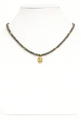 Collar corto de cristalitos facetados color gris con detalles dorados y dije dorado de la Virgen María.