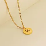 Collar dorado con dije redondo con el signo de Aries grabado.