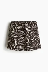 Short marrón con estampado de hojas blancas, cintura elástica con cordón ajustable y bolsillos laterales.