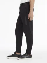 Pantalón de jogging negro de algodón con cintura elástica ajustable con cordón, bolsillos laterales, puños elásticos y logo de Calvin Klein bordado en la pierna.