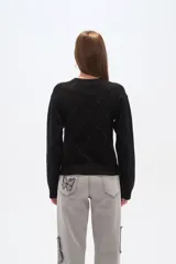 Sweater negro con cuello redondo y diseño de rombos grises.