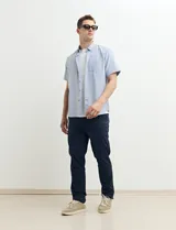 Camisa de manga corta con cuello abotonado y estampado a rayas verticales color beige y blanco.