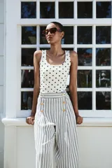 Camiseta blanca con lunares negros, de poliamida, corte ajustado, escote redondo y tirantes anchos.