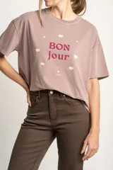Remera color lila con estampa frontal de la frase 'Bon jour' con estrellas y labios.
