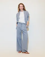 Pantalón de lino celeste con efecto vintage, corte ancho, tiro medio, pinzas delanteras, bolsillos laterales inclinados, raya de aplomo y bolsillos traseros ojal y con tapa.