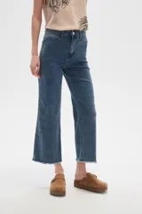 Pantalón jean blanco, recto y de calce alto con terminación desflecada.