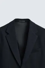 Blazer regular fit confeccionado en tejido con 17% de lana. Cuello con solapas de muesca. Manga larga acabada en puño con detalle de botones. Bolsillo de vivo en pecho y de solapa en cadera. Detalle bolsillo interior. Bajo con aberturas en espalda. Cierre frontal con botones.