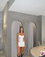 Corset blanco con breteles finos y paneles de tul transparente.