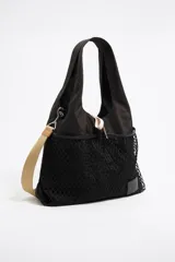 Bolso de mano grande de nailon negro con estructura blanda. Tiene doble asa de mano, asa de tejido regulable, etiqueta logotipada BIMBA Y LOLA, acabados metálicos, bolsillo interior y cierre de cordón.