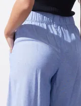 Pantalón crop de lino color celeste, marca Dash, con pretina trasera elastizada y bolsillos inclinados delanteros.