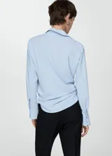 Camisa negra de corte clásico, con mangas largas y cierre frontal.