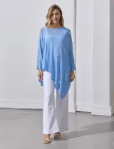 Poncho blanco de tejido calado con lurex, terminación asimétrica y cuello redondo.