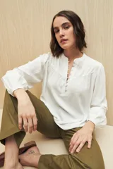 Camisa celeste de manga larga en viscosa suave, con cuello mao y botonadura parcial al frente. El detalle de frunces en los hombros y los puños abotonados le suman delicadeza y estilo.