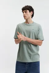 Remera color salmón de corte clásico, cuello redondo y logo bordado en el pecho.