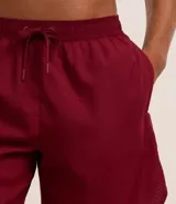 Bermuda deportiva masculina color gris oscuro, confeccionada en poliéster con textura perforada y cintura ajustable con lazo.