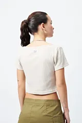 Remera cropped de ribb color crudo, con escote cuadrado y manga corta.