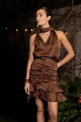 Top marrón con lunares blancos, reversible, con opción halter o escote en V y puntilla. Ajustado en la cintura y falda con volados. 