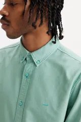 Camisa celeste de manga larga con cuello abotonado.